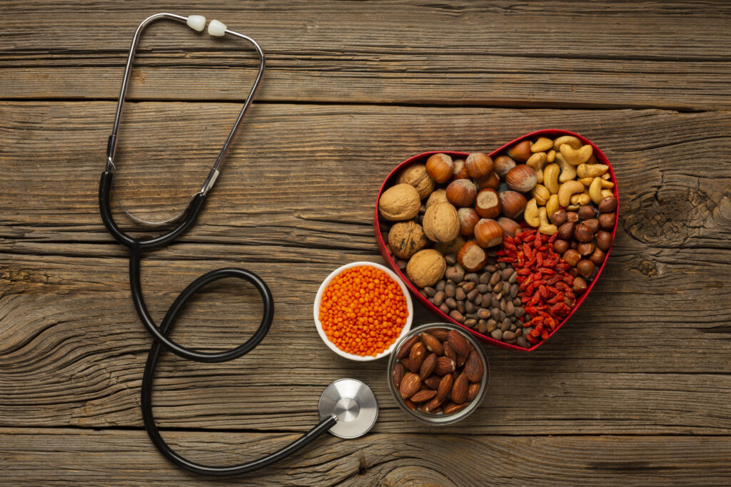 The image shows a stethoscope and heart-shaped arrangement of nuts and lentils, suggesting a focus on heart health.